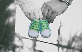 Male And Female hand carrying small sneakers